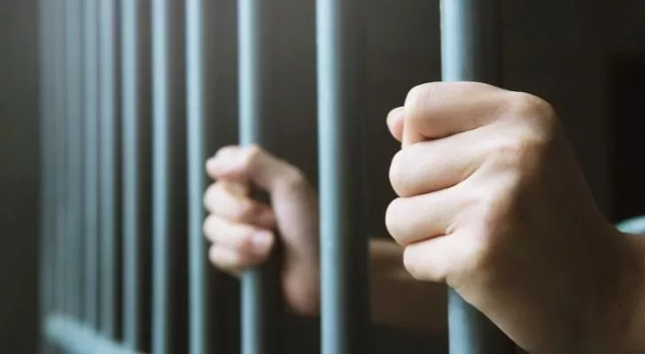 Person holding prison bars